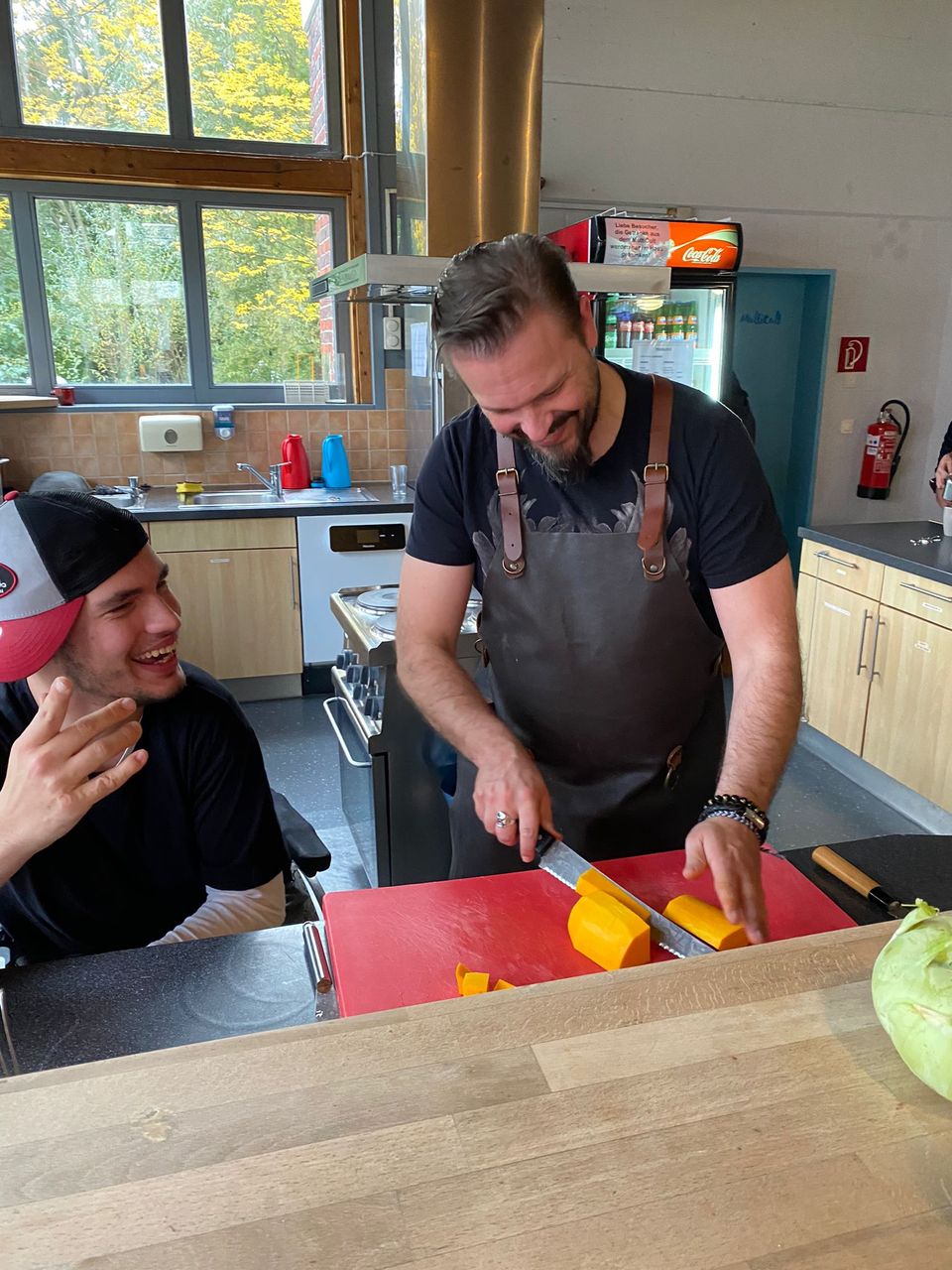 463888966_543880098339455_7642744811191594185_n Der Koch Christoph Hesse schneidet mit einem Jungen Kürbisse klein.