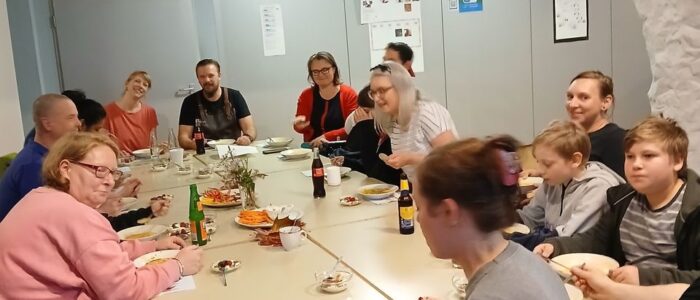 Eine große Gruppe sitzt am Tisch und isst die Suppe.