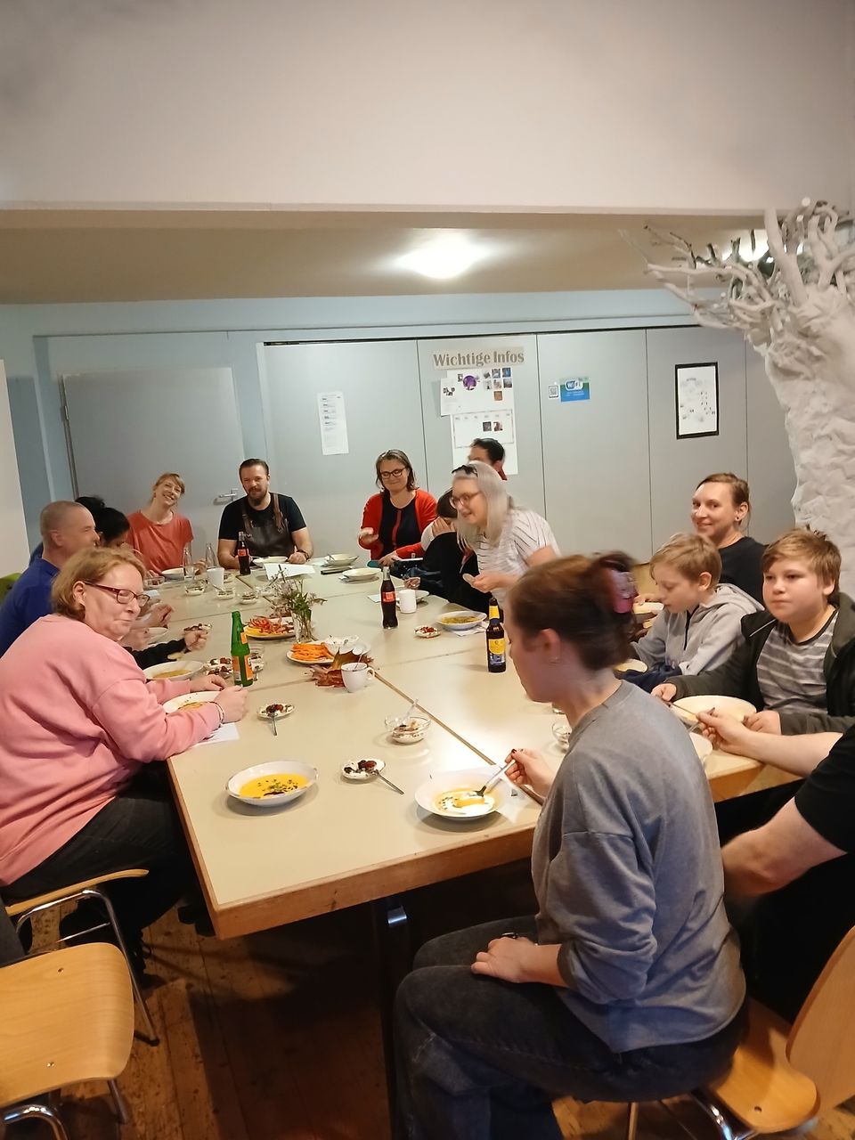 464028000_543881785005953_1129501664707825674_n Eine große Gruppe sitzt am Tisch und isst die Suppe.