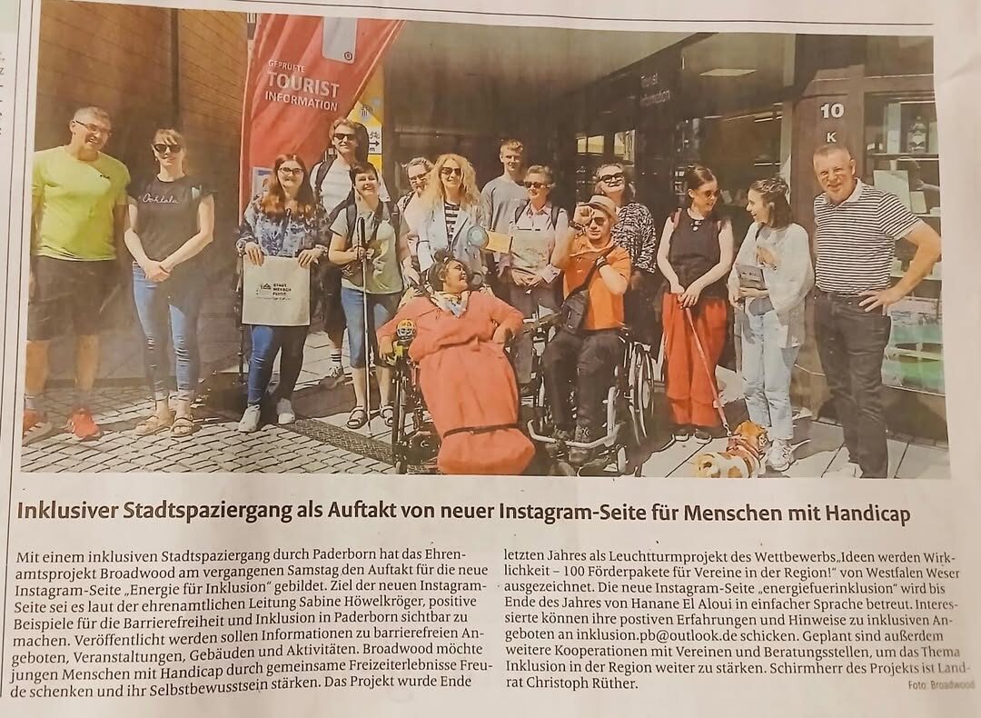 Das Bild zeigt einen Zeitungsartikel. Auf dem Foto ist eine Gruppe von Menschen vor der Tourist Information in Paderborn. Die Gruppe hat einen inklusiven Stadtspaziergang gemacht. Einige Menschen nutzen einen Rollstuhl. Alle stehen oder sitzen zusammen für ein Gruppenfoto. Der Artikel berichtet über das Projekt „Energie für Inklusion“.